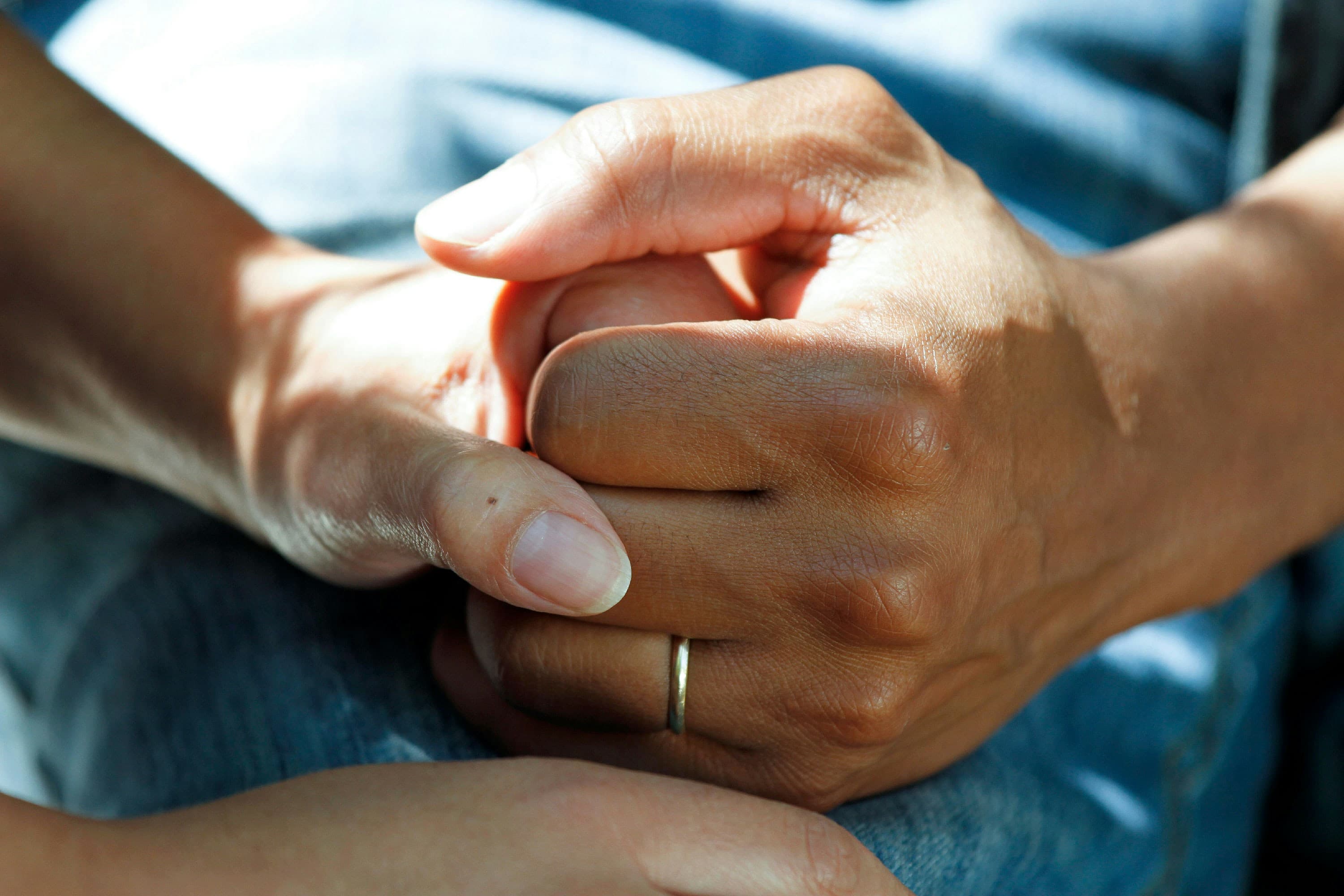 Two hands clasped together, symbolizing support and connection